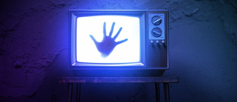 Scary-movie style scene of hand on television screen.
